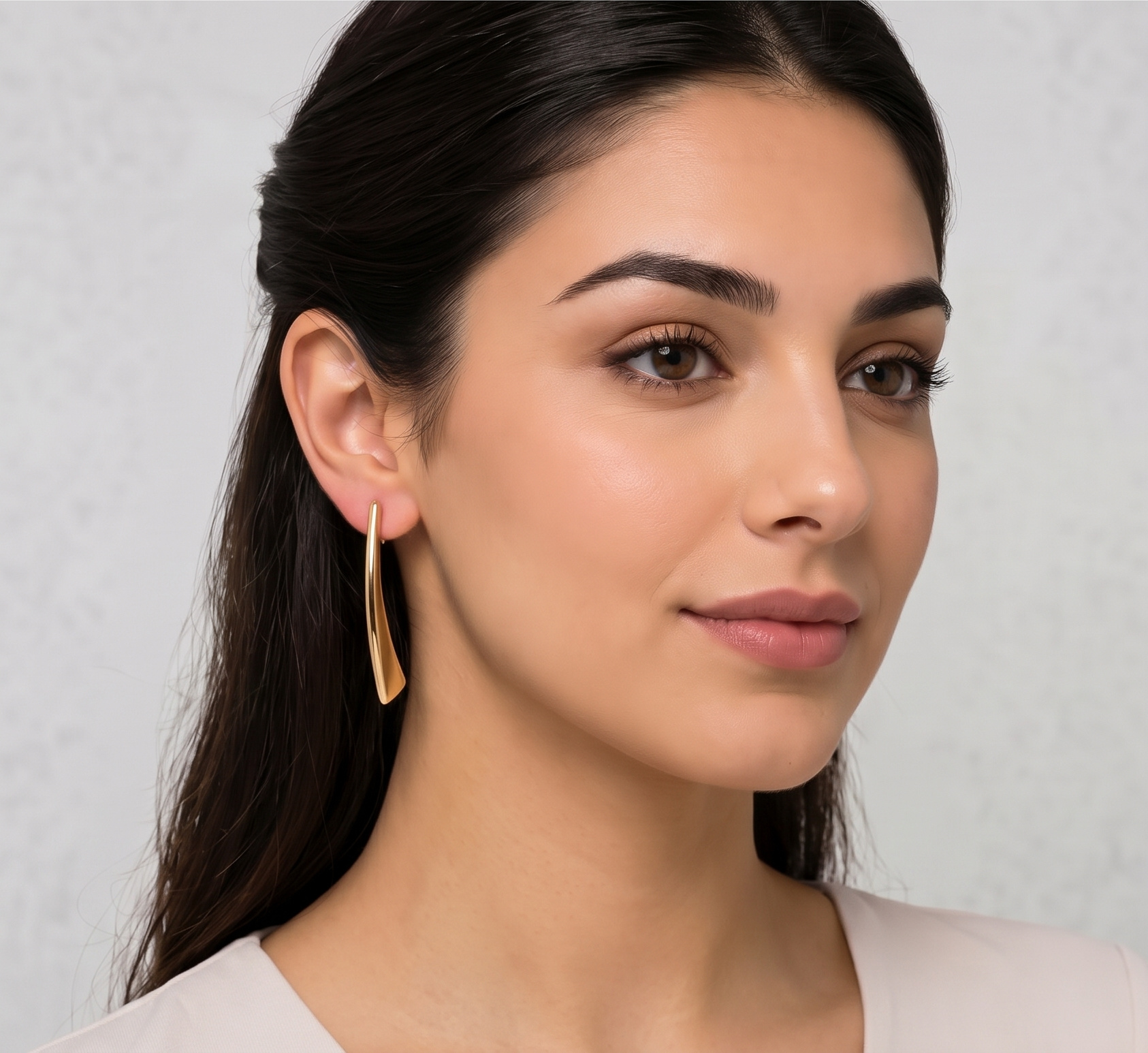 گوشواره آویزدار طرح کمانی طلایی روی گوش